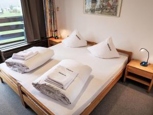 ディゼンティスにあるApartment Utoring Acletta-120 by Interhomeの白い枕が備わる客室内のベッド2台