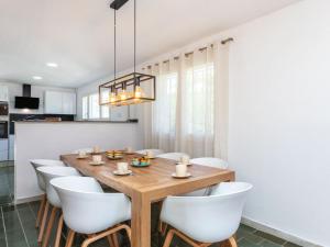 a dining room with a wooden table and white chairs at Villa Vilafortuny by Interhome in Vilafortuny +23 photos