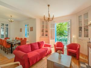 a living room with a red couch and a table at Holiday Home Jeanne d'Arc-1 by Interhome in Saint-Palais-sur-Mer