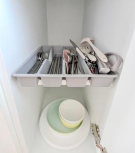 a cupboard with dishes and utensils in a kitchen at Harmony Stay in Seoul