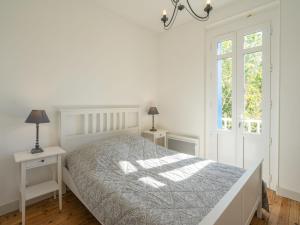 um quarto branco com uma cama e duas mesas de cabeceira em Holiday Home Jeanne d'Arc-1 by Interhome em Saint-Palais-sur-Mer