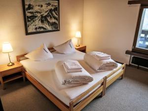 ディゼンティスにあるApartment Utoring Acletta-139 by Interhomeのベッドルーム1室(白いシーツと枕のベッド2台付)