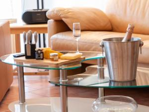- une table basse en verre accompagnée d'un verre de vin dans l'établissement Apartment Teetied by Interhome, à Norddeich