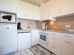 een keuken met witte kasten en witte apparaten bij Apartment Domaine de la Greve by Interhome in Saint-Pierre-Quiberon