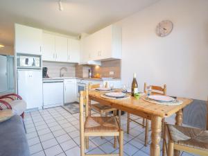 een keuken en eetkamer met een houten tafel bij Apartment Domaine de la Greve by Interhome in Saint-Pierre-Quiberon