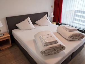 un letto con due cuscini e asciugamani di Apartment Utoring Acletta-132 by Interhome a Disentis