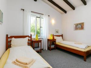 two beds in a room with a window at Apartment Residence Miralago - Utoring Apt- B15 by Interhome in Piazzogna