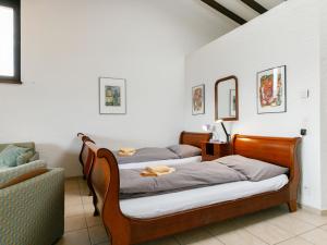 2 camas en una habitación con sofá y espejo en Apartment Miralago - Utoring-21 by Interhome en Piazzogna