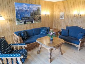 a living room with blue couches and a table at Apartment Utoring Acletta-138 by Interhome in Disentis
