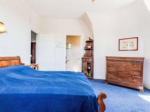 1 dormitorio con cama azul y tocador de madera en Apartment Le Caneton-4 by Interhome en Cabourg