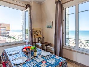 comedor con mesa y vistas al océano en Apartment Le Caneton-4 by Interhome en Cabourg