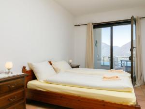 um quarto com uma cama e uma janela com vista em Apartment Residence Miralago - Utoring Apt- B16 by Interhome em Piazzogna