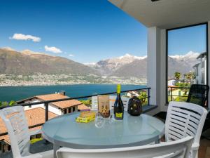 a table with a bottle of wine on a balcony at Apartment Residence Miralago - Utoring Apt- B16 by Interhome in Piazzogna +15 photos
