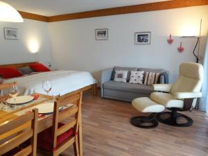 een slaapkamer met een bed, een tafel en een bank bij Apartment Am Dürrbach 5-512 by Interhome in Engelberg