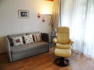 - un salon avec un canapé et une chaise dans l'établissement Apartment Am Dürrbach 5-512 by Interhome, à Engelberg