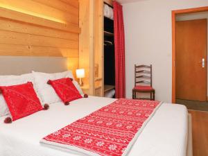 1 dormitorio con 1 cama con almohadas rojas en Apartment Diamant 6 by Interhome, en Villars-sur-Ollon