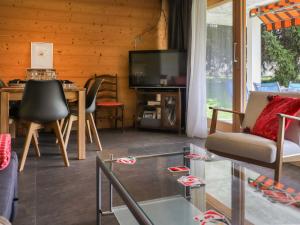 a living room with a tv and a table and chairs at Apartment Diamant 6 by Interhome in Villars-sur-Ollon +22 photos