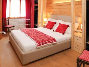a bedroom with a bed with red pillows on it at Apartment Diamant 6 by Interhome in Villars-sur-Ollon