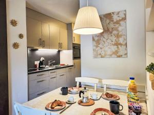 eine Küche mit einem Tisch und Teller mit Lebensmitteln darauf in der Unterkunft Apartment Parcolago - Utoring-57 by Interhome in Caslano