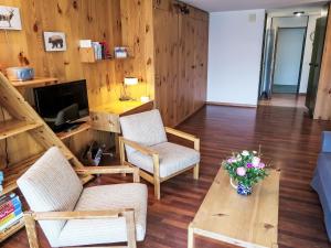 un soggiorno con 2 sedie e un tavolo di Apartment Utoring Acletta-84 by Interhome a Disentis