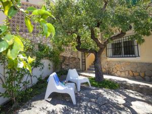 due sedie bianche sedute sotto un albero accanto a un edificio di Holiday Home Villa Sol by Interhome a Calpe