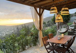 a table and chairs on a porch with a view at Villa Kotseli - Sea View, Pool, Sunsets in Andros