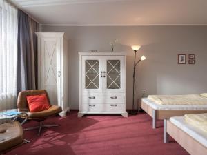 ラーンシュタインにあるApartment B1010 by Interhomeのベッドルーム1室(ベッド1台、キャビネット、椅子付)