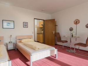 ラーンシュタインにあるApartment B1010 by Interhomeのベッドルーム1室(ベッド1台、椅子2脚付)