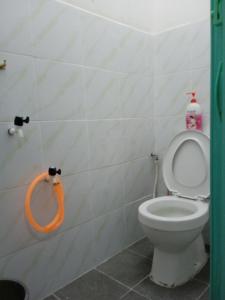 a bathroom with a toilet with an orange hose at Rest House Idaman BB Rumah tak kongsi in Kuala Terengganu