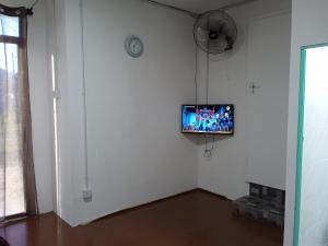 a living room with a tv on a white wall at Rest House Idaman BB Rumah tak kongsi in Kuala Terengganu