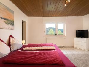 - une chambre avec un lit et une couette rouge dans l'établissement Holiday Home Haus Annes by Interhome, à Quiddelbach