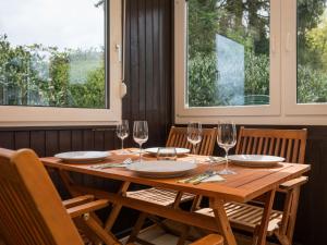 einen Holztisch mit Stühlen und Weingläsern in der Unterkunft Holiday Home Haus Annes by Interhome in Quiddelbach