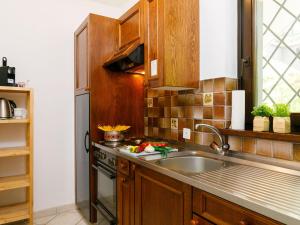 a kitchen with a sink and a stove at Apartment Miralago - Utoring-24 by Interhome in Piazzogna