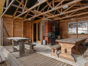 um alpendre de uma cabina de madeira com bancos e um fogão em Holiday Home Villa kaisla by Interhome em Risulahti