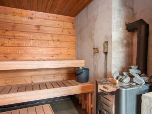 uma sauna com uma parede com painéis de madeira e um fogão em Holiday Home Villa kaisla by Interhome em Risulahti