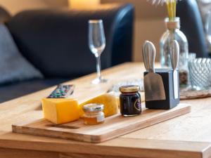 ein Holzschnitttafel mit Käse und einem Weinglas in der Unterkunft Apartment Strandläufer by Interhome in Norddeich