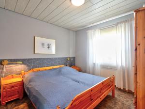 a bedroom with a wooden bed and a window at Holiday Home Dorf 4- Haus 27 by Interhome in Kirchheim