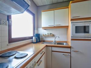 eine Küche mit einer Spüle und einer Mikrowelle in der Unterkunft Holiday Home Dorf 4- Haus 27 by Interhome in Kirchheim