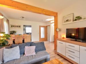 ein Wohnzimmer mit einem Sofa und einem TV in der Unterkunft Holiday Home Dorf 4- Haus 27 by Interhome in Kirchheim