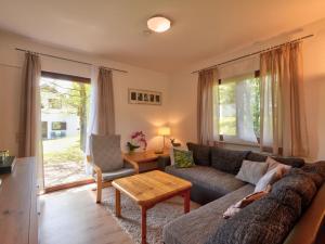 ein Wohnzimmer mit einem Sofa und einem Tisch in der Unterkunft Holiday Home Dorf 4- Haus 27 by Interhome in Kirchheim