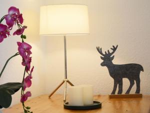 a lamp on a table with a deer stencil on a wall at Holiday Home Dorf 4- Haus 27 by Interhome in Kirchheim +41 photos