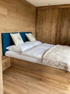 a large bed in a room with wooden walls at Obereggut in Hof bei Salzburg