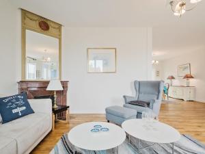a living room with a couch and a chair and two tables at Apartment L'Anse by Interhome in Dinard