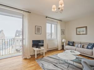 a living room with a couch and a tv at Apartment L'Anse by Interhome in Dinard +21 photos