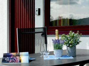 a table with a bottle of wine and flowers on it at Holiday Home Dorf 1-Haus 14 by Interhome in Kirchheim