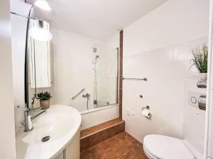 Baño blanco con aseo y lavamanos en Apartment Flieder - F 96 by Interhome, en Dittishausen