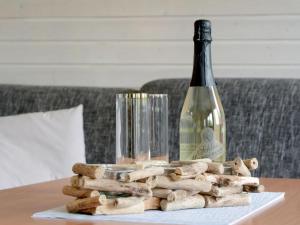 una botella de vino en una mesa con un montón de madera en Holiday Home Seepark Kirchheim-7 by Interhome, en Kirchheim