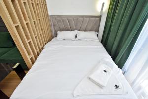 a bed with two white towels on top of it at Wooden rest 9 in Yerevan