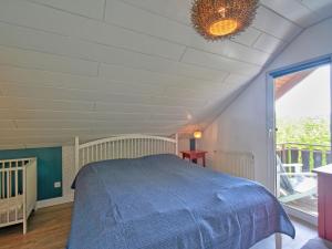a bedroom with a bed with a blue blanket at Holiday Home Seepark Kirchheim-8 by Interhome in Kirchheim