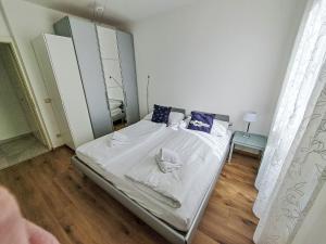 a bedroom with a bed with white sheets and blue pillows at Apartment Vinzek by Interhome in Töschling